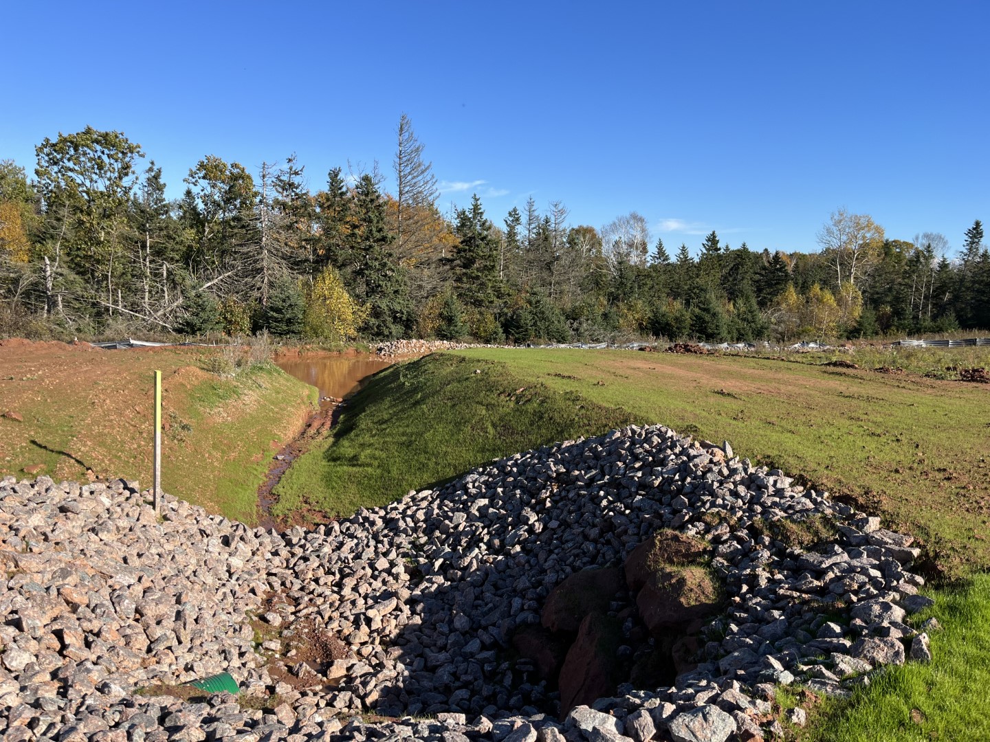 Woodland Creek drainage ditch with large rock close to culvert.